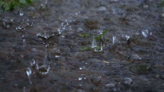 暴雨下雨雨滴落在地面上溅起水花