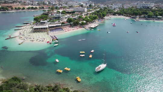 空中蔚蓝海滩，带空躺椅和船巴尔干海岸阿尔巴尼亚