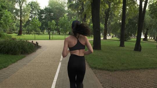 女孩在公园跑步的背影