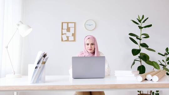 穆斯林女士坐在电脑前工作