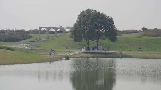 湖边绿地有人休憩散步的自然风景