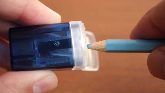 K26。用带刨花容器的卷笔刀削铅笔。