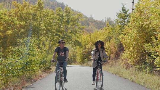 夏季森林中的旅行者情侣骑自行车