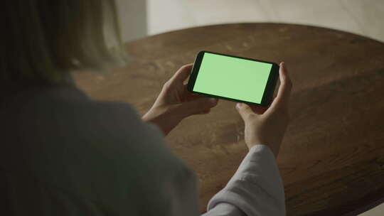 女人拿着带绿屏的智能手机视频素材模板下载
