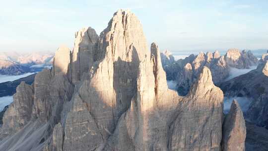 令人印象深刻的Tre Cime di Lavaredo塔被日出、白云石照亮；空中视频素材模板下载