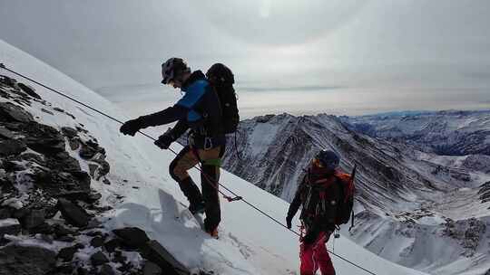 攀登四川岷山山脉主峰雪宝顶的登山者