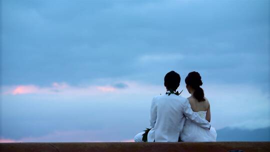 新婚夫妇坐在海边