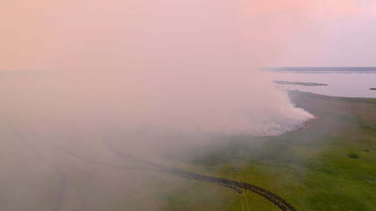 水上绿地上空烟云的鸟瞰图显示野火对环境的