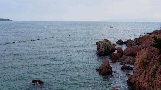 实拍青岛海岸线晚霞海水礁石与游客乘船视频