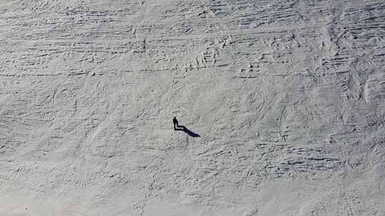 一个人爬白雪覆盖的山的鸟瞰图