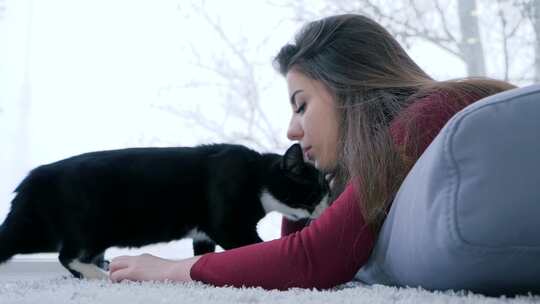 女人在室内窗边抚摸一只猫