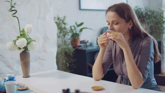 年轻迷人的女人在茶道上喝茶