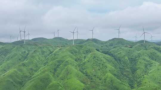 绿色山丘上的风力发电机群全景