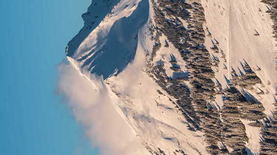 在法国阿尔卑斯山的阿沃里亚兹滑雪场，云层在山顶上飘荡。垂直格式延时。