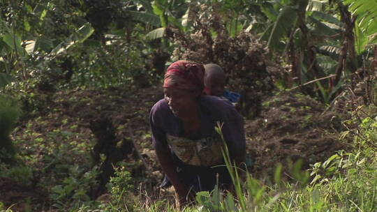 非洲妇女背着孩子爬山