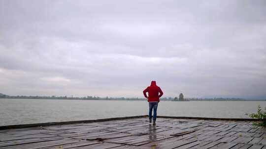 穿红色卫衣的男人独自站在江边视频素材模板下载