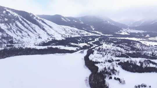 航拍新疆冬季喀纳斯湖雪景雪山森林冰河晨雾