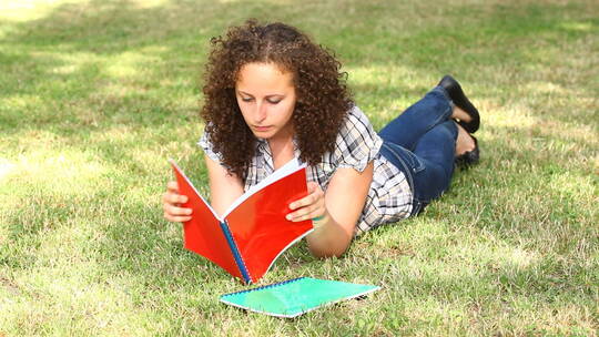 女学生在草地上看书