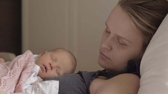 母亲和新生的女儿睡在一起视频素材模板下载