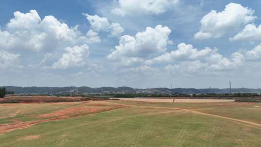 航拍云南红河红色土地夏天草地水库岸边