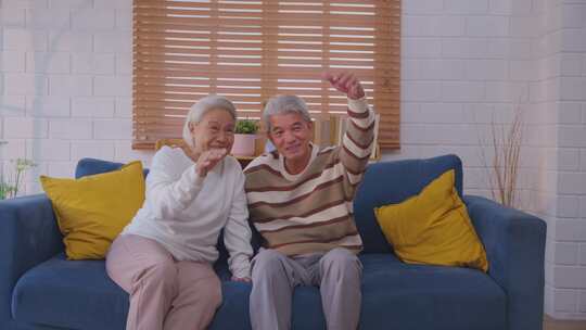 亚洲老年夫妇和女儿坐在沙发上的肖像。