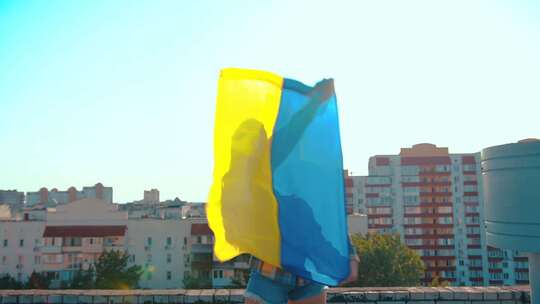 挂着乌克兰国旗的房子屋顶上的美丽女人视频素材模板下载