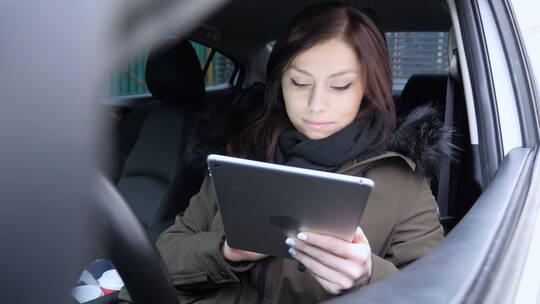 女人在车里看平板电脑视频素材模板下载