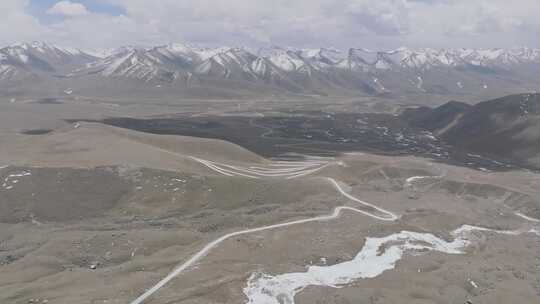 航拍西藏拉萨琼穆岗嘎雪山下的盘山公路