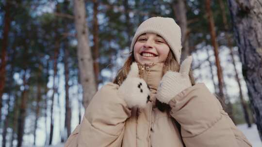 森林里下雪的冬日，快乐的小女孩微笑着