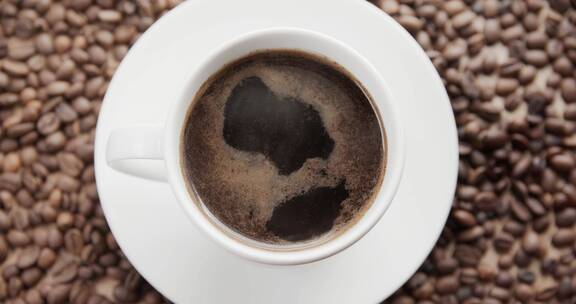 俯拍放在咖啡豆堆中的热咖啡
