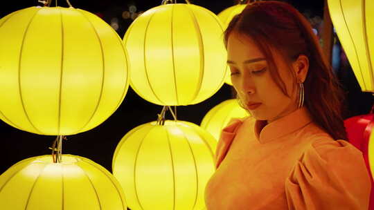 穿着传统服装微笑着打着黄色灯笼的美丽越南