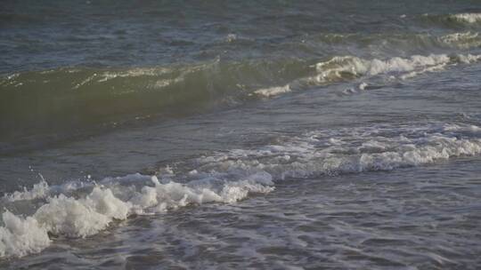 潮水海边海浪浪花拍打在沙滩礁石上