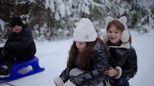 孩子们在雪地里玩雪橇冬天快乐的概念