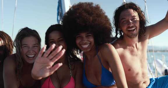 快乐的多种族朋友用帆船进行海上旅行——夏季和假期概念