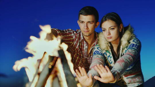 一对幸福的恋人在篝火取暖视频素材模板下载