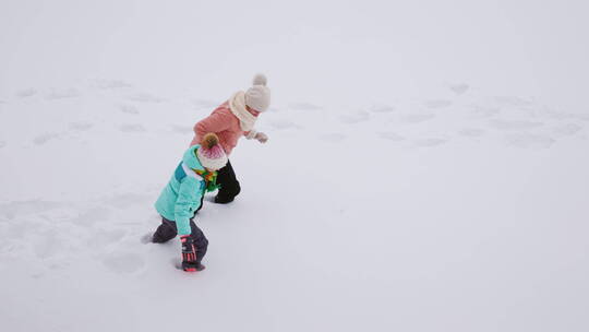在厚厚的雪地里行走的母女