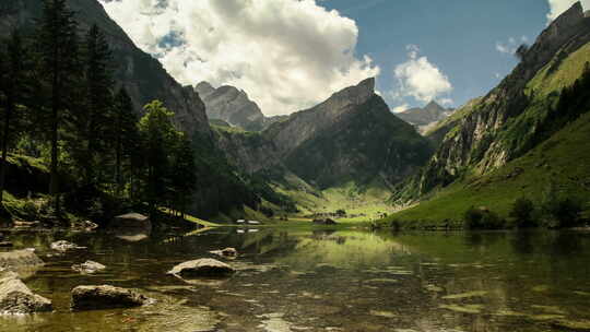 延时云彩漂浮在瑞士阿尔卑斯山的Seealpsee湖上