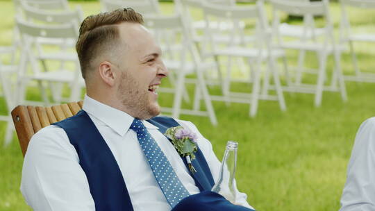 坐在婚礼木椅笑的男人
