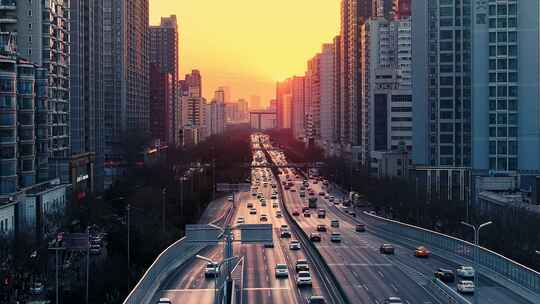 城市夕阳下繁忙道路上行驶的汽车