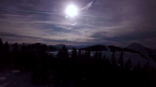 低云下的雪山和冬天日落时的蓝天。美丽的全景景观