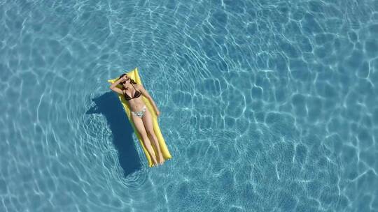 一名女子在游泳池享受夏日阳光