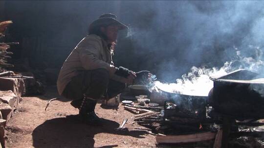 一个牛仔坐在火边抽烟
