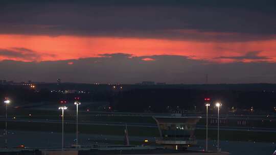 飞机在日落时分从控制塔后面起飞