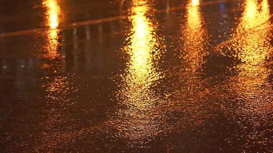 4K灯光映照下的雨夜路面金色涟漪