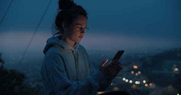 年轻女子在夕阳下看手机