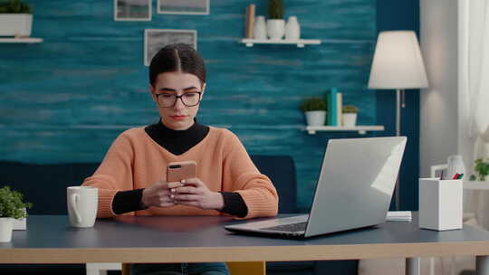坐在办公桌前使用智能手机浏览互联网的人