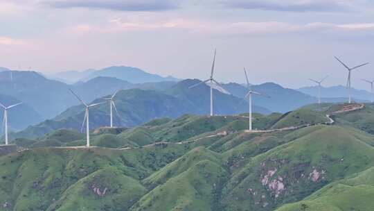 绿色山丘上的风力发电机群全景