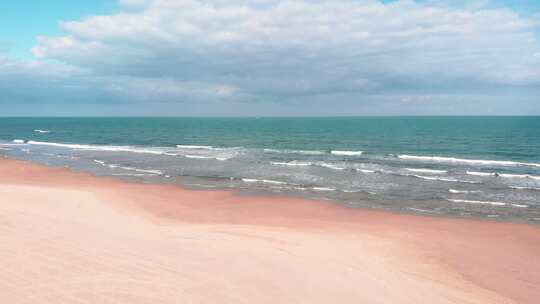 广阔空旷的沙滩绿松石海浪