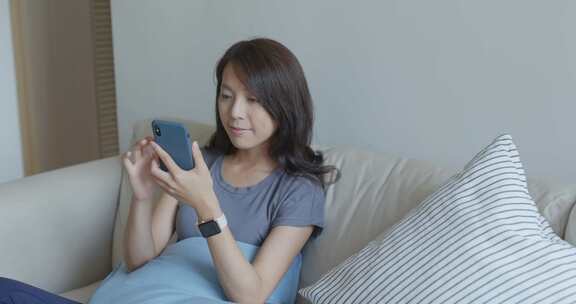 女子沙发上使用手机