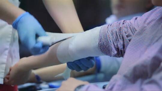 医生用绷带包扎病人的手臂视频素材模板下载